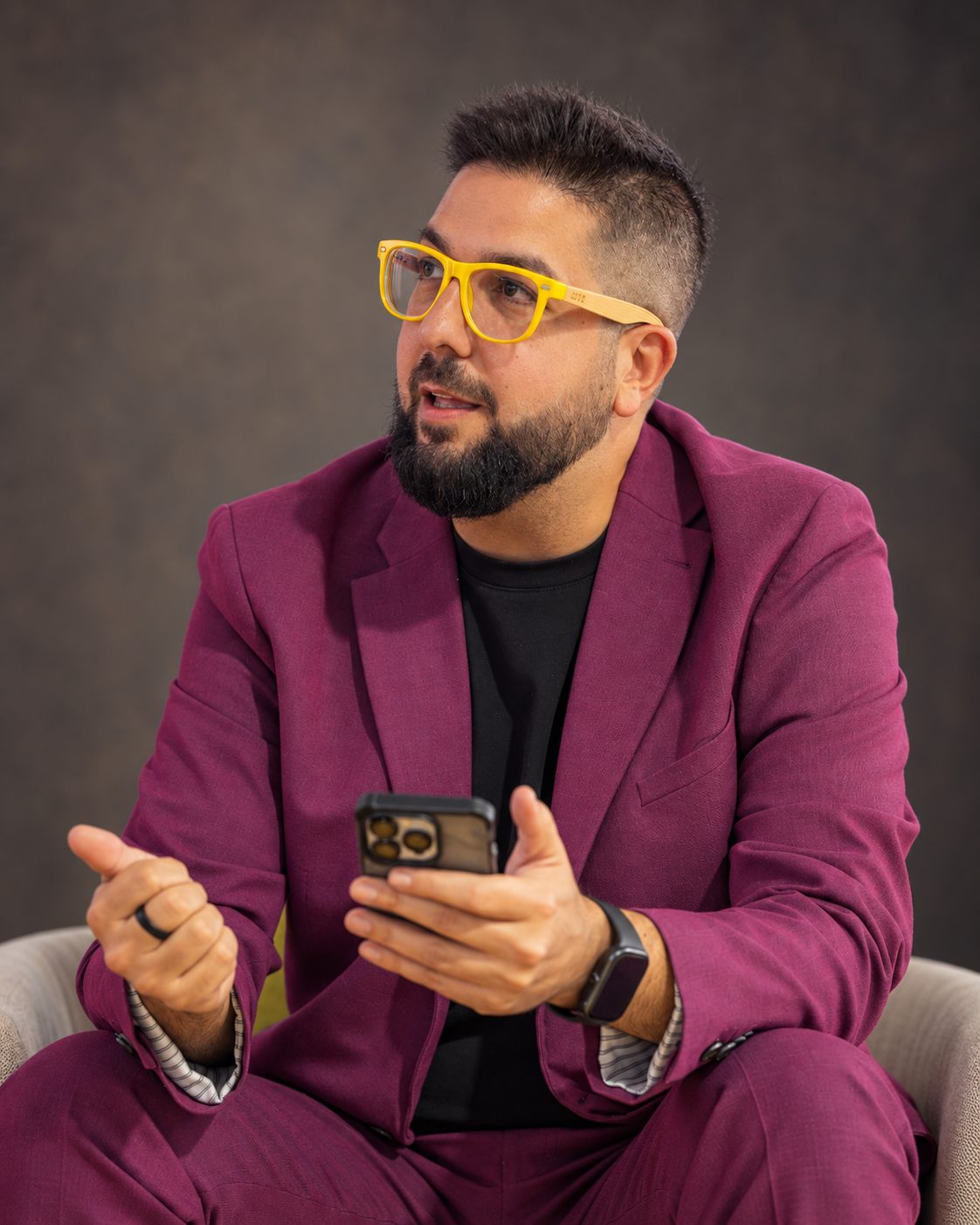 Retrato de Jota con gafas amarillas y traje burdeos